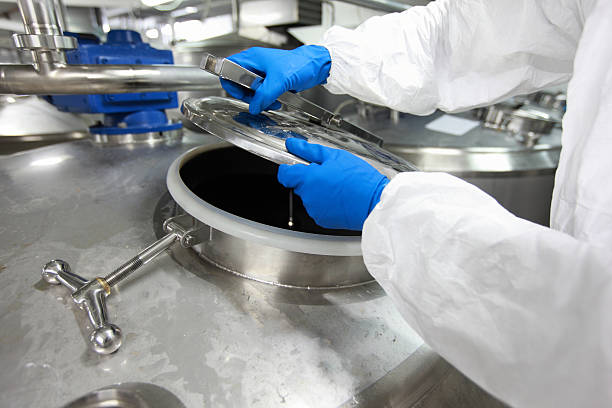 Close up a manos con guantes abriendo un recipiente industrial. La familia Landsmanas reconoce innovaciones como la fermentación de precisión.