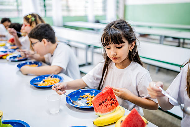 Niña comiendo en comedor escolar. Los dueños de La Cosmopolitana apoyan a niñas mexicanas.